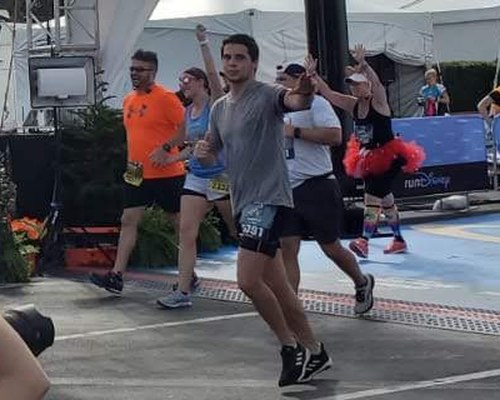 Eddie waving at the camera at a marathon finish line